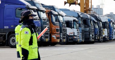Police officers walk past a parked truck at a terminal of the Inland Container Depot in Uiwang, South Korea, Nov., 30, 2022. (Reuters Photo)