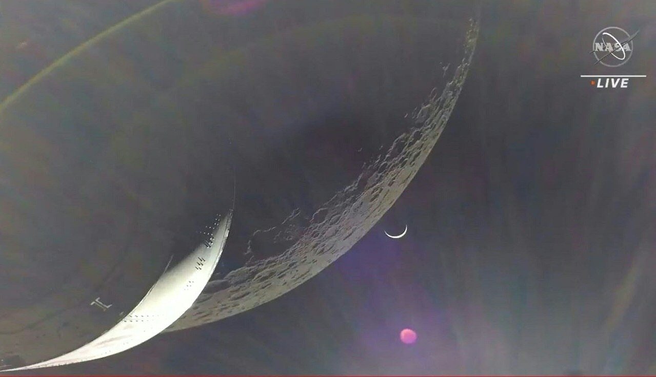 In this video grab, the Earth is visible as a crescent in the minutes after Orion finished its engine burn around the moon, Space, Dec. 5, 2022. (NASA TV Handout via AFP)