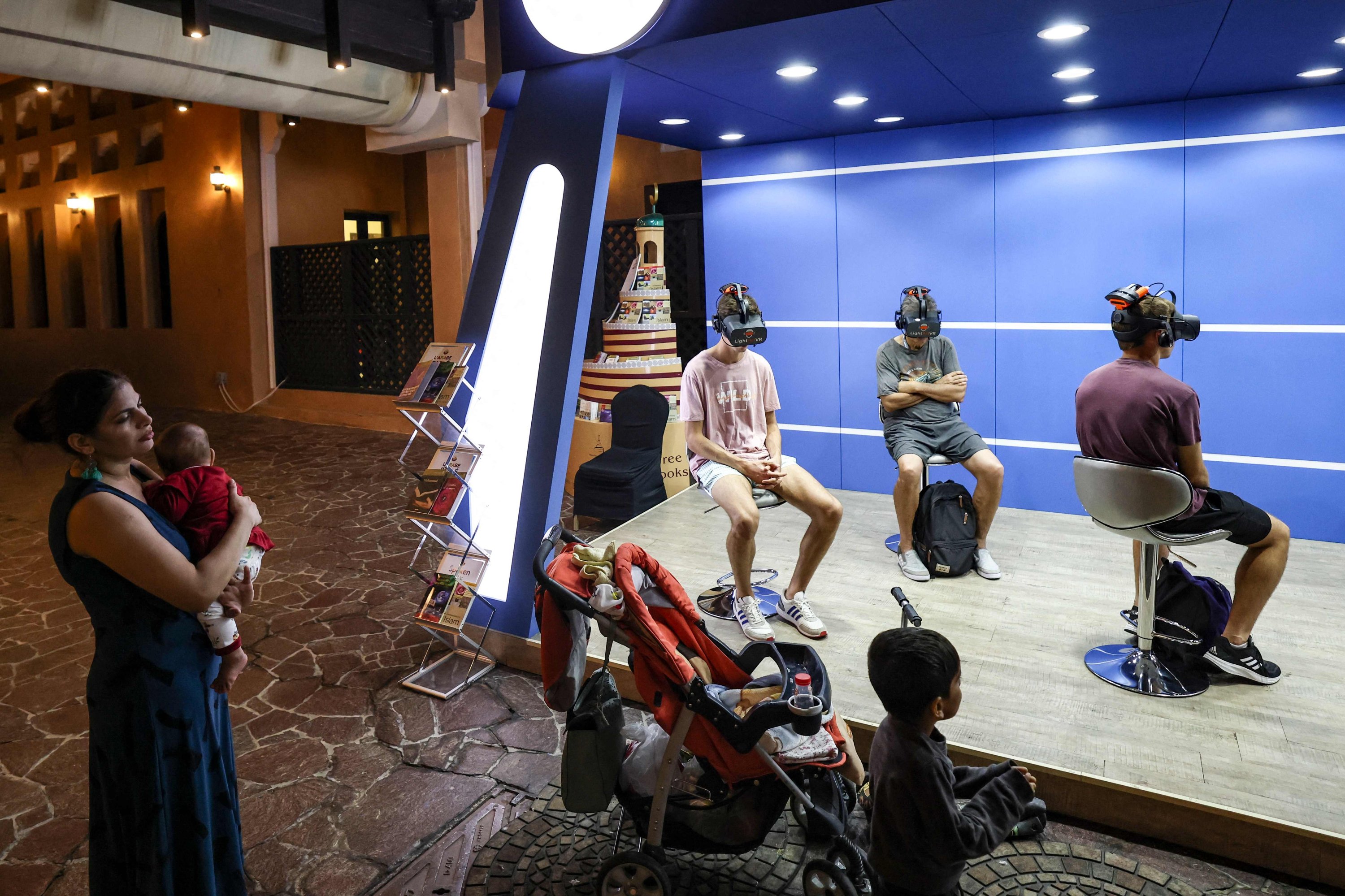 Penggemar sepak bola muda menonton tur realitas virtual Islam selama lima menit, di dekat Masjid Biru Doha, Doha, Qatar, 29 November 2022. (AFP Photo)