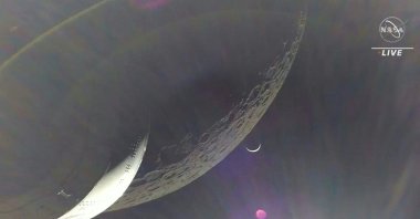 In this video grab, the Earth is visible as a crescent in the minutes after Orion finished its engine burn around the moon, Space, Dec. 5, 2022. (NASA TV Handout via AFP)