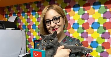 Vet Ümmühan Deniz holds a cat implanted with a microchip and his "passport," in Eskişehir, central Türkiye, Dec. 6, 2022. (İHA Photo) 