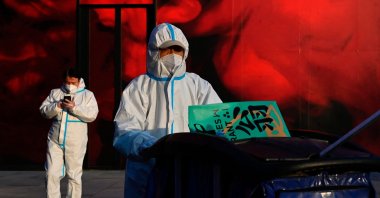 Cleaning workers in protective gear clean up garbages at a shopping mall in Beijing on December 6, 2022. (Photo by Jade Gao / AFP)