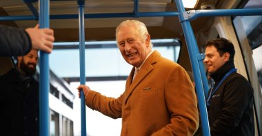Britain's King Charles III travels in a DART carriage, to the Luton DART central terminal, during a visit to Luton DART Parkway Station in Luton, north of London where he learned about the new cable-drawn mass passenger transit system which will connect Luton Airport Parkway rail station to London Luton Airport, Dec 6. (AFP Photo)