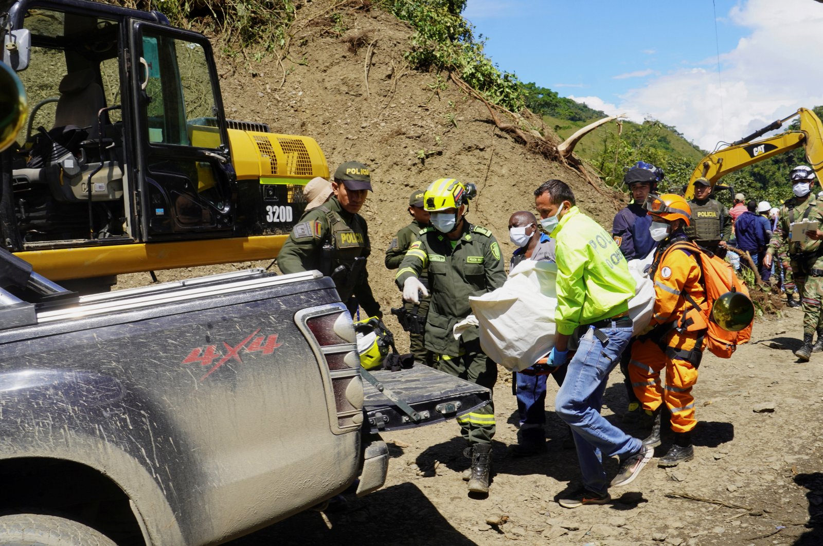 Rescuers carry the body of a deceased person after a bus was buried by a landslide, Pueblo Rico, Colombia, Dec. 5, 2022. (Reuters Photo)