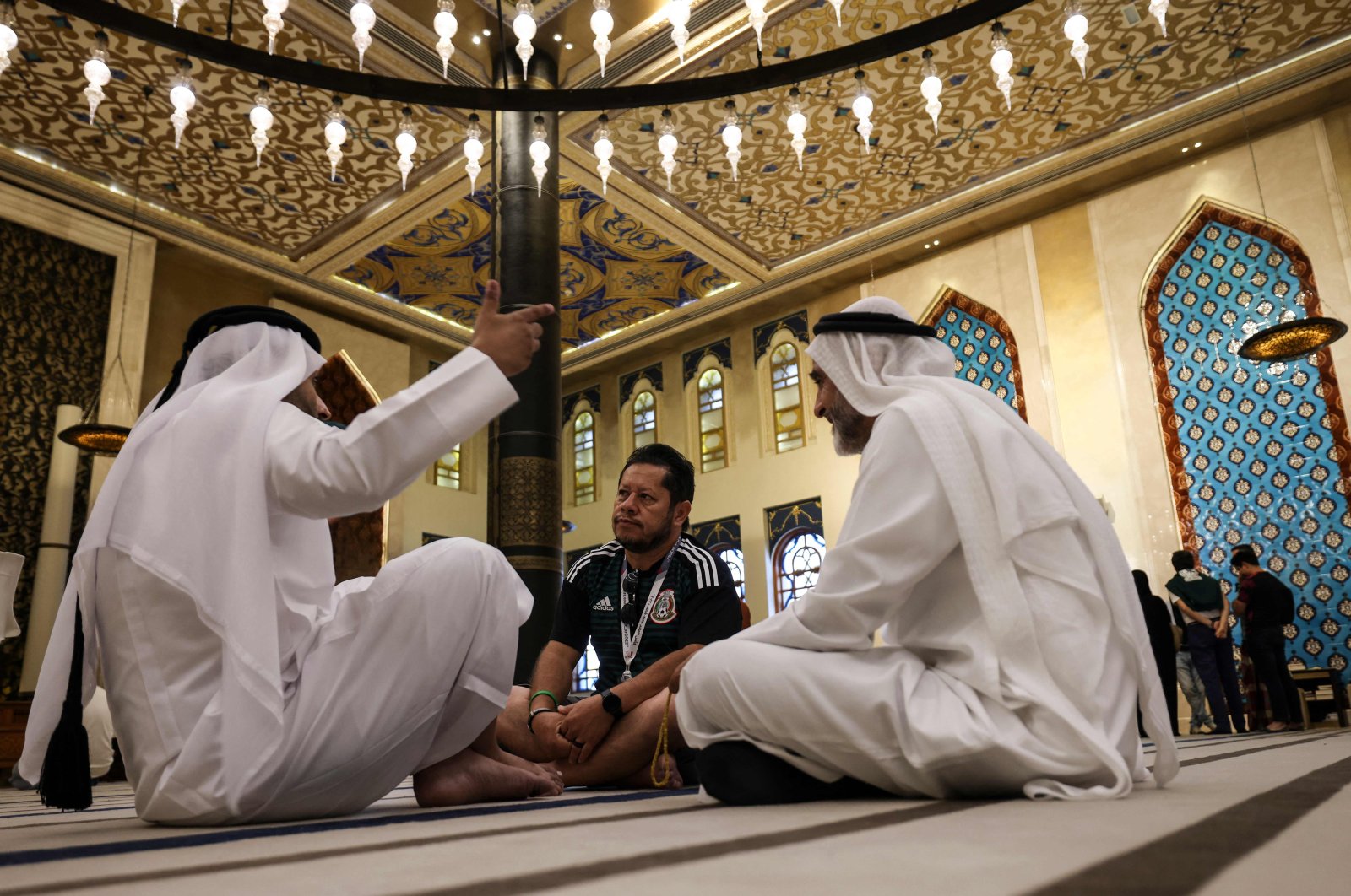 A football fan chats with Gulf residents inside Doha&#039;s Blue Mosque, Doha, Qatar, Nov. 29, 2022. (AFP Photo)