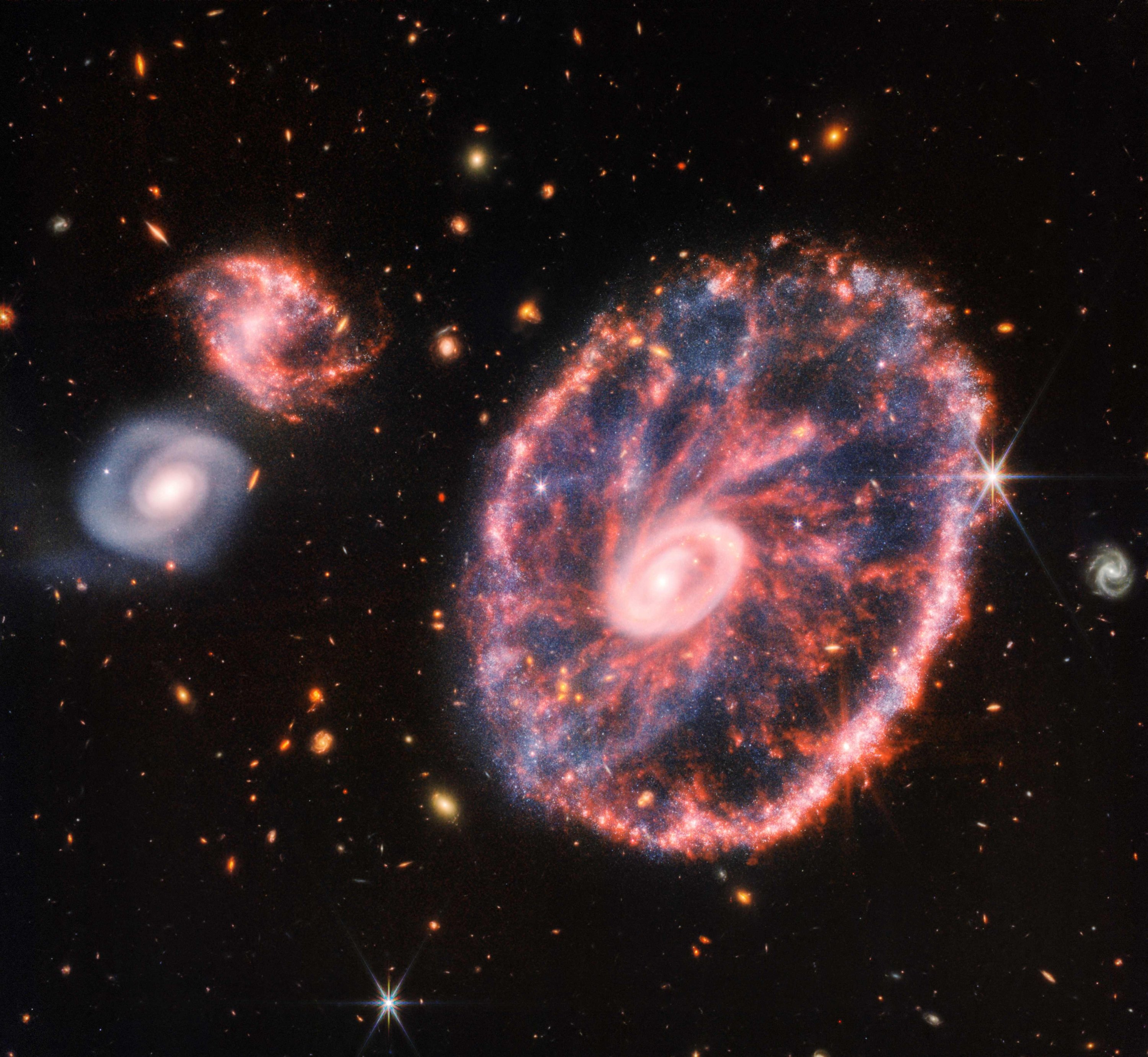 Gambar komposit menunjukkan Cartwheel dan galaksi pendampingnya, mengungkap detail yang sulit dilihat hanya dalam gambar individual, 2 Agustus 2022. (Foto AFP)