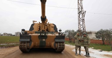 In this file photo taken on Feb. 12, 2020, Turkish soldiers stand next to a Turkish 155 mm self-propelled artillery gun in the town of Binnish in northwestern Syria's province of Idlib, near the Syria-Türkiye border. (AFP Photo)