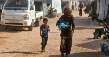 Displaced Syrian children return to their tents at a camp for displaced people on the outskirts of the opposition-held town of Dana, in Idlib province, Syria, April 30, 2022 (AFP Photo)