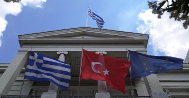 Greek (L) Turkish (C) and European Union flags wave on the foreign ministry house before a meeting betwen Greek Foreign Minister Nikos Dendias and his Turkish counterpart Mevlüt Çavuşoğlu in Athens, Greece, May 31, 2021. (AP File Photo)