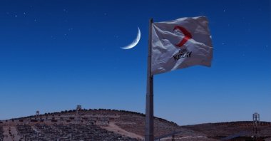 A Turkish Red Crescent (Kızılay) flag flies over a cluster of briquette homes Türkiye has constructed in northern Syria. Dec. 7, 2022. (Photo by Uğur Yıldırım)