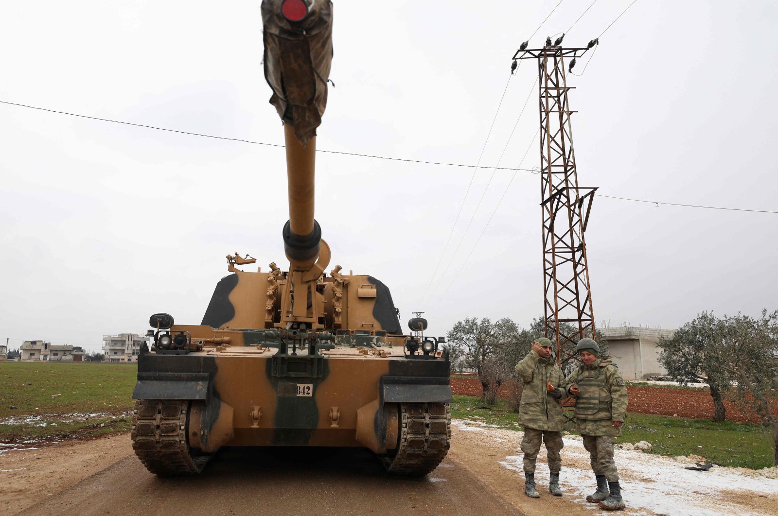 In this file photo taken on Feb. 12, 2020, Turkish soldiers stand next to a Turkish 155 mm self-propelled artillery gun in the town of Binnish in northwestern Syria&#039;s province of Idlib, near the Syria-Türkiye border. (AFP Photo)