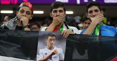 Spectators hold photo of Forman German international Mesut Özil on the stands at the end of the World Cup group E soccer match between Spain and Germany, at the Al Bayt Stadium in Al Khor, Doha, Qatar, Nov. 28, 2022. (AP Photo)