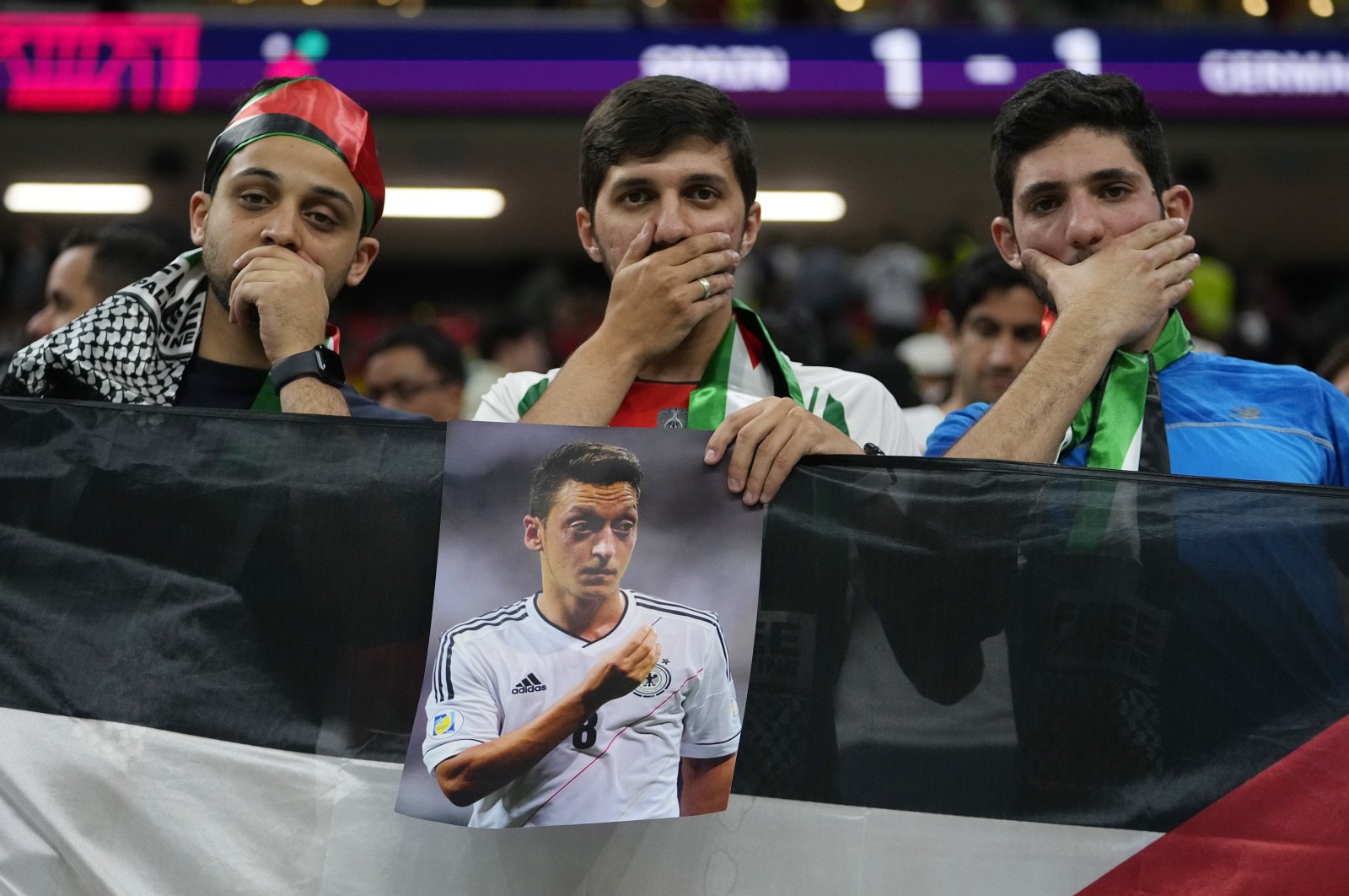 Spectators hold photo of Forman German international Mesut Özil on the stands at the end of the World Cup group E soccer match between Spain and Germany, at the Al Bayt Stadium in Al Khor, Doha, Qatar, Nov. 28, 2022. (AP Photo)