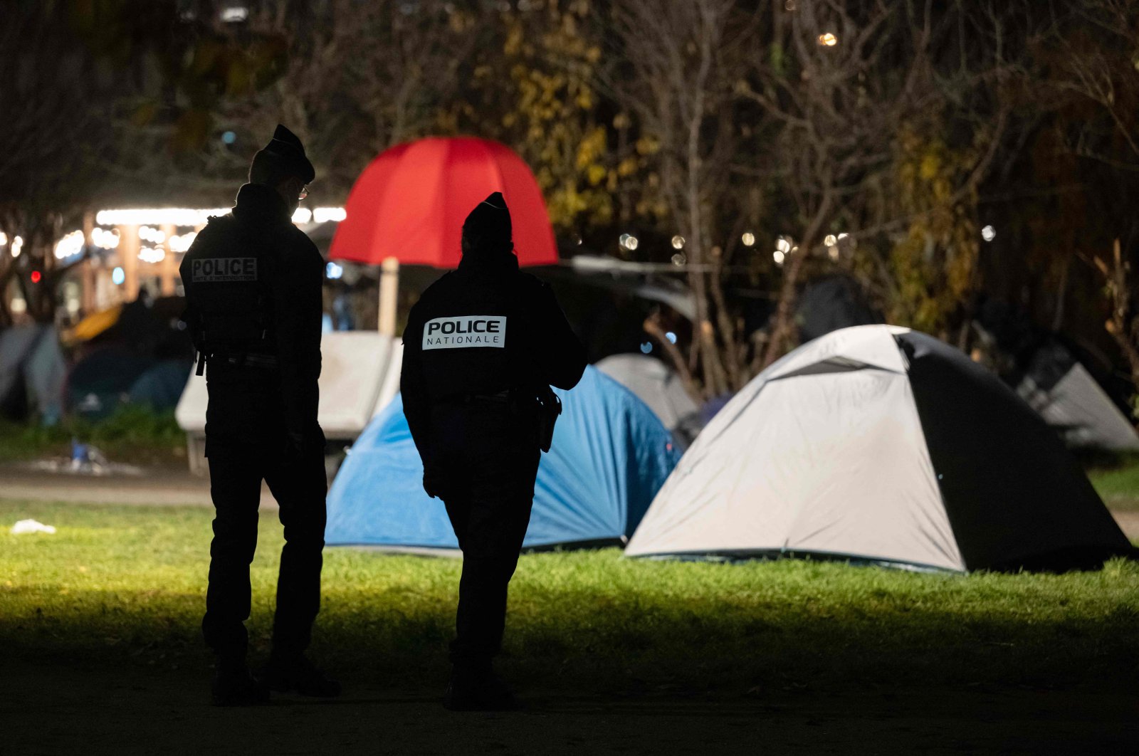 Police officers look for migrants during the evacuation of a makeshift camp implanted in front of the city hall in Strasbourg, eastern France, on Dec. 6, 2022. 