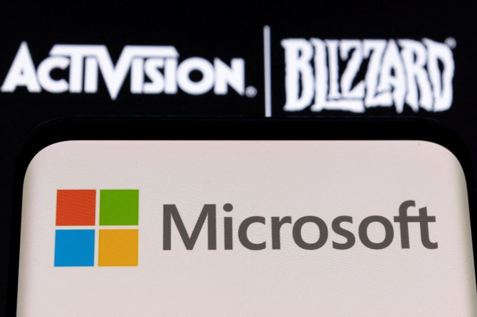 Microsoft logo is seen on a smartphone placed on displayed Activision Blizzard logo in this illustration taken Jan. 18, 2022. (Reuters Photo)