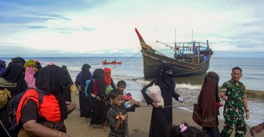 Rohingya migrants are escorted after their boat transporting 119 people landed on the coast of Bluka Teubai, North Aceh, Indonesia, Nov. 16, 2022. (AFP Photo)