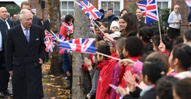 Britain's King Charles III meets pupils from new City junior school waving Union flags, London, U.K., Nov. 23, 2022. (AFP Photo)