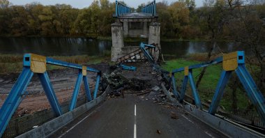 A tank painted with the letter "Z" lies at the bottom of a section of a destroyed bridge in Izium, Kharkiv region, Ukraine, Oct. 20, 2022. (Reuters Photo)