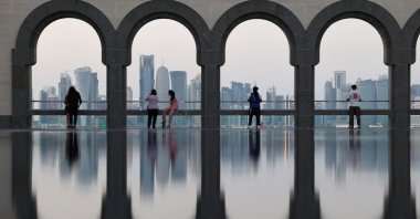 Visitors explore the Museum of Islamic Art (MIA), backdropped by the skyline of Doha, Qatar, Dec. 4, 2022. (EPA Photo)