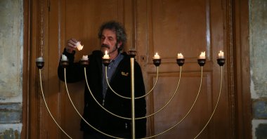 Head of Türkiye's Sephardic Culture Collective Nesim Bencoya is seen lighting a traditional menorah (the seven-branched candelabrum), Izmir, Türkiye, Nov. 30, 2022. (AA Photo)