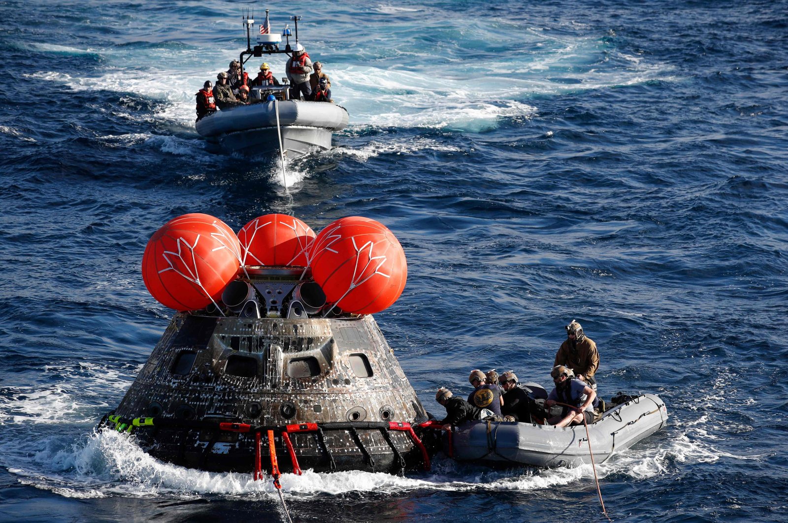 U.S. Navy divers attach winch cables to NASA&#039;s Orion capsule, off the coast of Baja California, Mexico, Dec. 11, 2022. (AFP Photo)