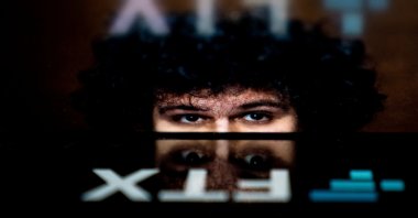 This photo illustration shows the logo of cryptocurrency FTX, reflected in an image of former chief executive Sam Bankman-Fried, Washington, U.S., Nov. 13, 2022. (AFP File Photo)