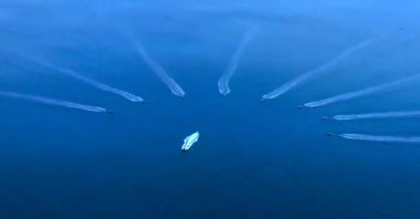 A screen-grab from the video Ismail Demir, the head of the Presidency of Defense Industries (SSB), shared showing the moment when the 8-herd swarm of indigenous armed unmanned surface vessels push away a suspicious boat, Ankara, Türkiye, Dec. 13, 2022. (DHA Photo)