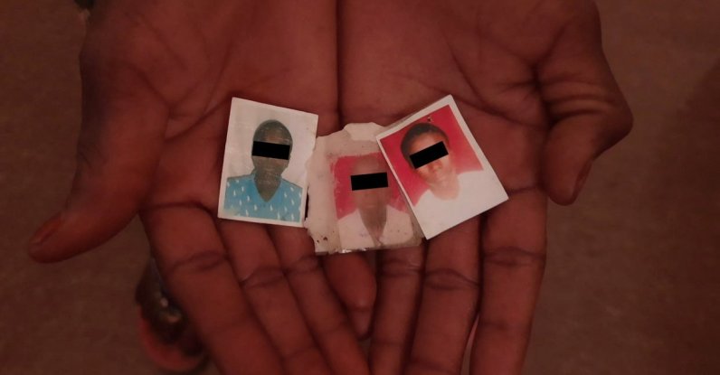 Falmata, a Nigerian grandmother in her 50s who told Reuters that Nigerian troops killed three of her grandchildren in the town of Gasarwa during a military operation in 2018, holds photographs of those grandchildren at an undisclosed location in Nigeria, Oct. 10, 2021. (Reuters Photo)