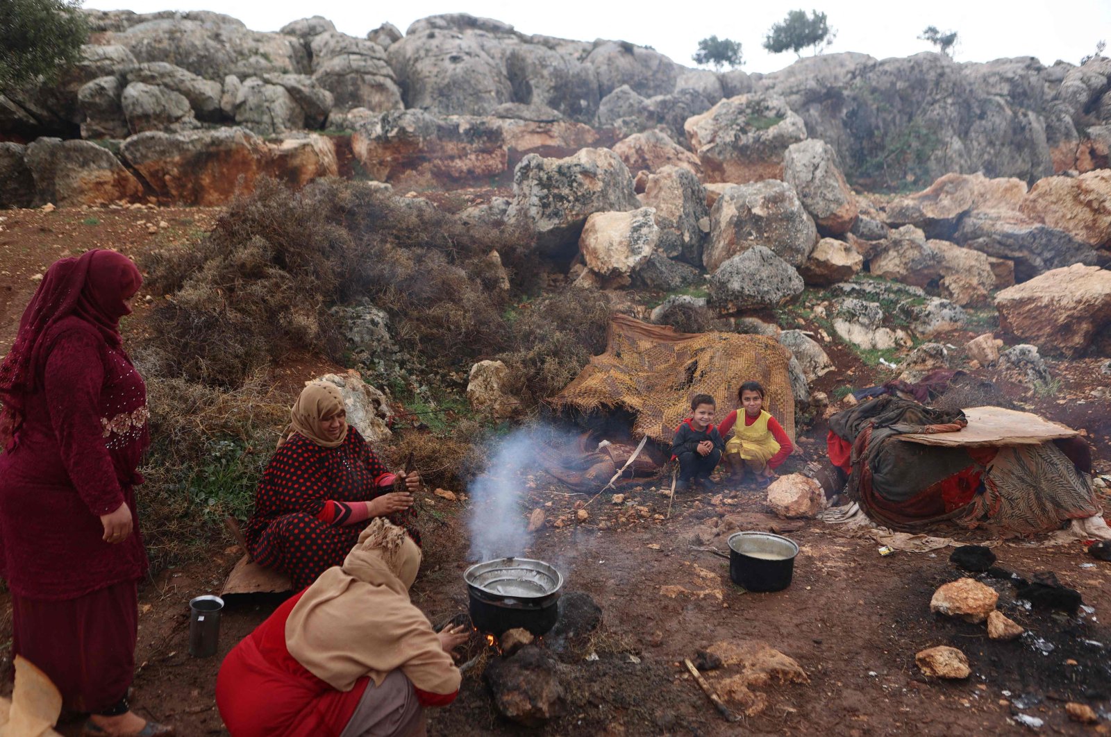 Women gather to cook after heavy rain, at the Kafr Arouk displacement camp in the opposition-held northern countryside of Syria&#039;s Idlib province, on Nov. 25, 2022. (AFP Photo)