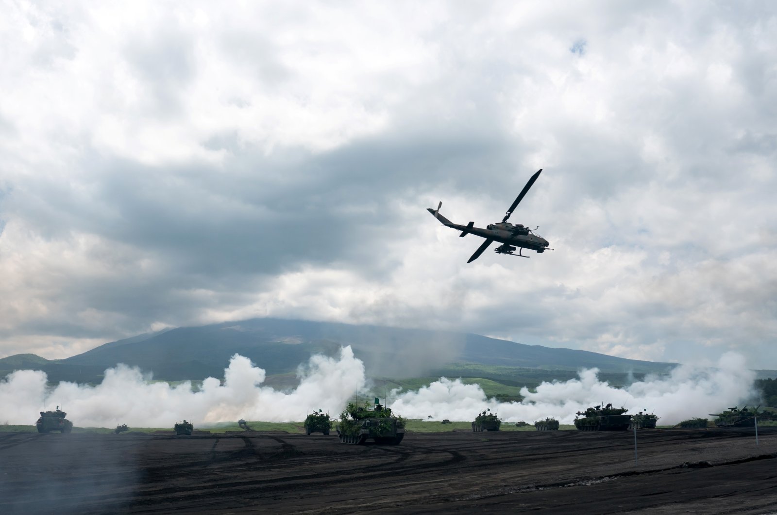 Japan Ground Self-Defense Force (JGSDF) battle tanks and a helicopter take part in the annual live-fire exercise at East Fuji Maneuver Area, in Gotemba, Shizuoka, Japan, May 28, 2022. (Reuters Photo)