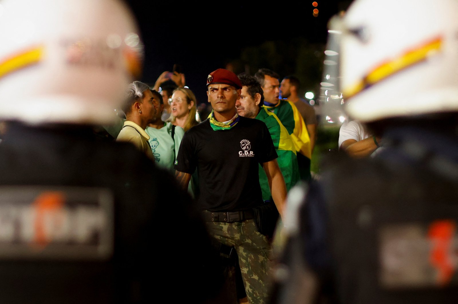 Police officers stand guard as supporters of Brazil&#039;s President Jair Bolsonaro protest after supreme court justice Alexandre de Moraes ordered a temporary arrest warrant of indigenous leader Jose Acacio Serere Xavante for alleged anti-democratic acts, in Brasilia, Brazil, Dec. 12, 2022. (Reuters Photo)