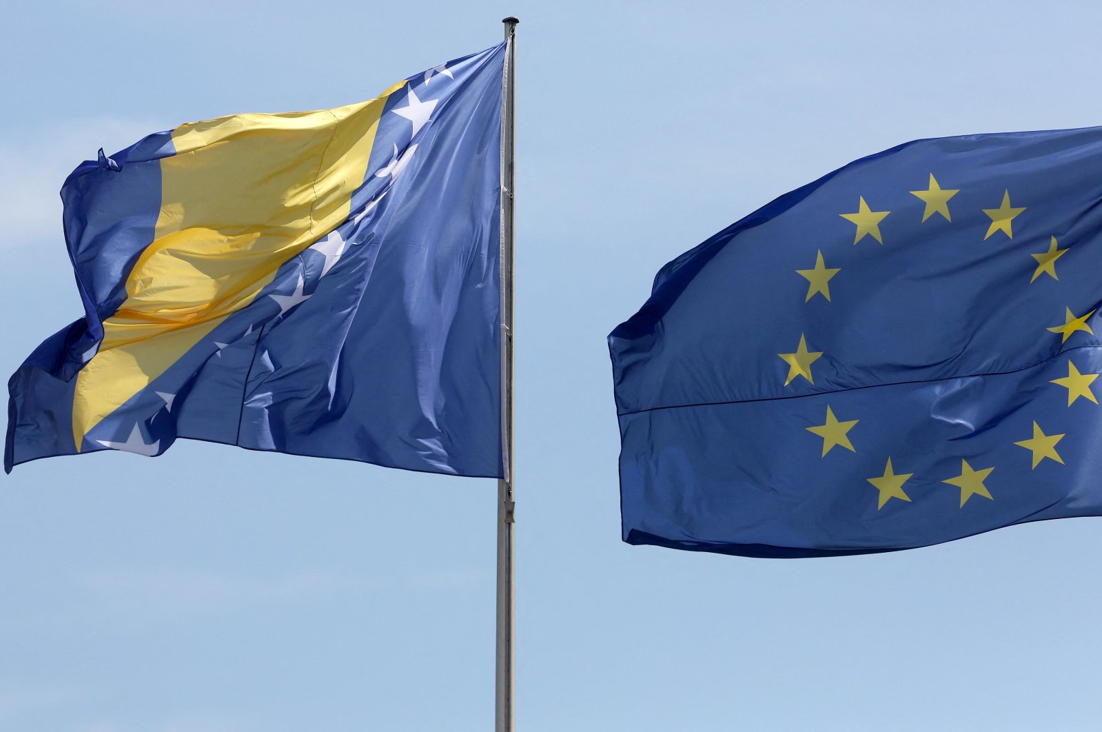 The national flag of Bosnia and Herzegovina (L) is pictured next to the EU flag, Berlin, Germany, Aug. 13, 2018. (AFP Photo)