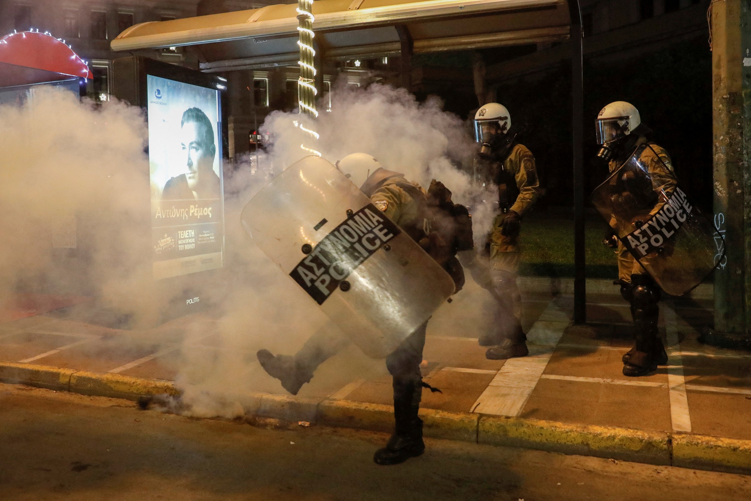Seorang petugas polisi anti huru hara menendang tabung gas air mata saat mereka bentrok dengan pengunjuk rasa selama demonstrasi, Thessaloniki, Yunani, 13 Desember 2022. (Foto Reuters)