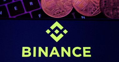 A smartphone displaying the Binance logo and a representation of cryptocurrencies on a keyboard are seen in this illustration, Nov. 8, 2022. (Reuters Photo)