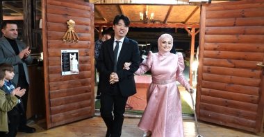 Semanur Kutanis (R) and Koo Dongwan enter the hall for their engagement party in Rize, Türkiye, Dec. 14, 2022. (DHA Photo)