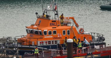 Migrants picked up at sea while attempting to cross the English Channel are escorted off the U.K. Royal National Lifeboat Institution (RNLI) lifeboat at the Marina, Dover, U.K., Dec. 14, 2022. (AFP Photo)