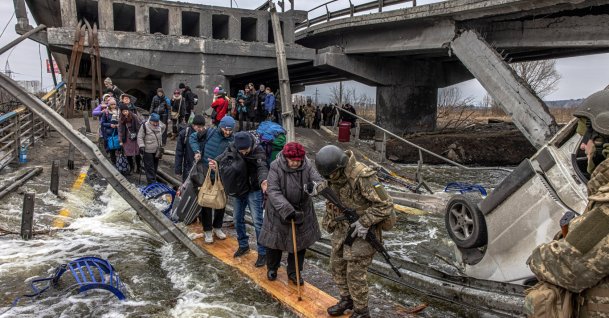 People cross a destroyed bridge as they flee from the front line town of Irpin, Kyiv region, Ukraine, March 7, 2022.  (EPA Photo)