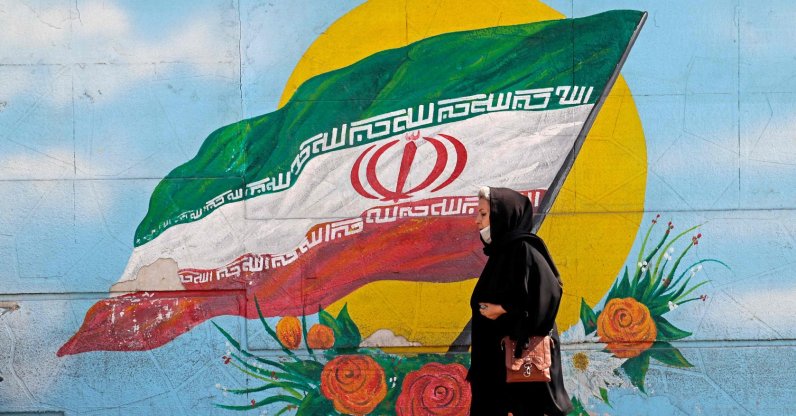 A woman walks past a mural in Tehran, Iran, Oct. 11, 2022. (AFP Photo)