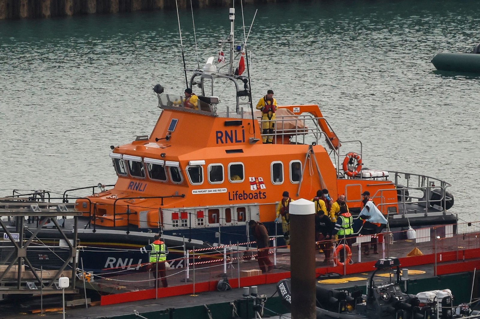 Migrants picked up at sea while attempting to cross the English Channel are escorted off the U.K. Royal National Lifeboat Institution (RNLI) lifeboat at the Marina, Dover, U.K., Dec. 14, 2022. (AFP Photo)