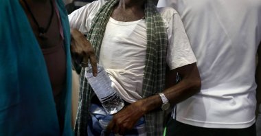 A customer carries a bottle after buying alcohol at a liquor store in Kolkata, eastern India, May 15, 2021. (EPA Photo)