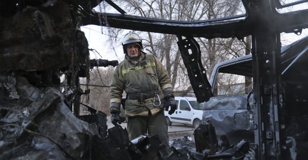 A firefighter examines a burned car after what Russian officials in Donetsk said was a shelling by Ukrainian forces, in Donetsk, eastern Ukraine, Dec. 15, 2022. (AP Photo)