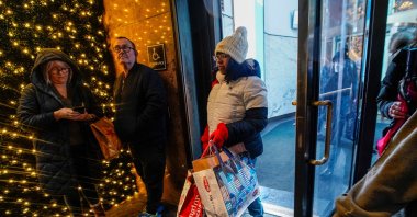 People carrying shopping bags exit a retail store during the holiday season in New York City, U.S., Dec. 15, 2022. (Reuters Photo)