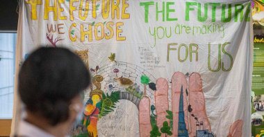 People walk past a poster during the United Nations Biodiversity Conference COP15, in Montreal, Quebec, Canada, Dec. 18, 2022. (AFP Photo)