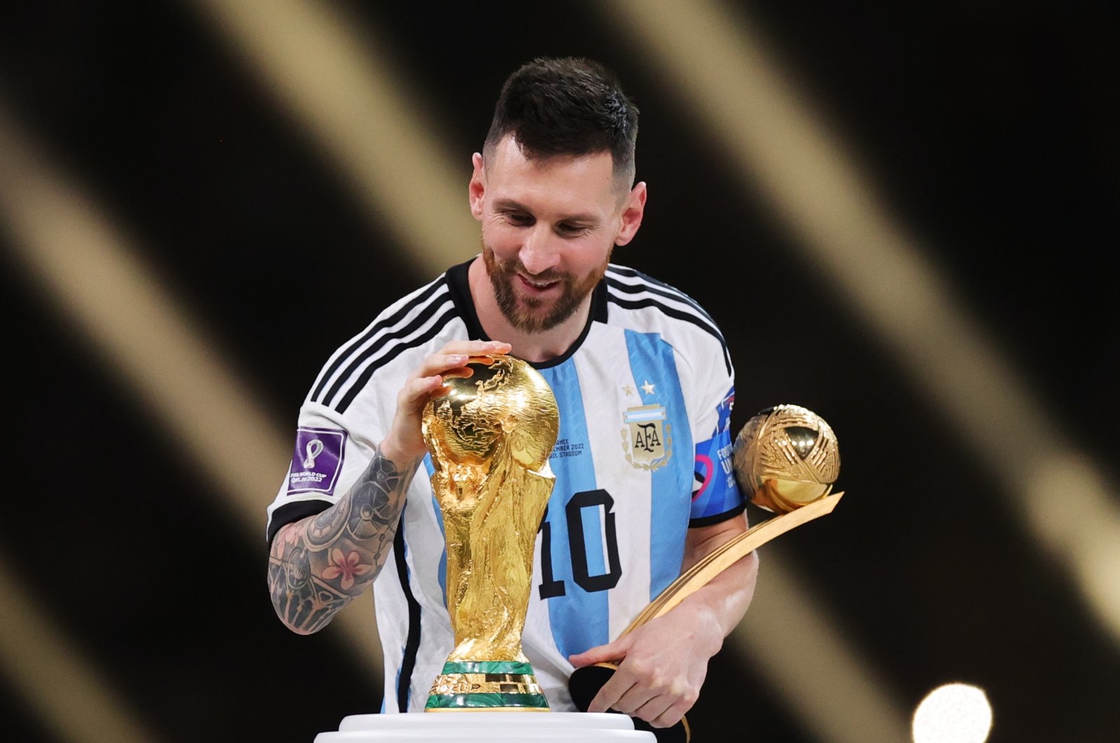 Lionel Messi of Argentina touches the World Cup trophy as he passes it after winning the golden ball award during the awards ceremony after the FIFA World Cup 2022 final between Argentina and France at Lusail stadium, Lusail, Qatar, Dec. 18 2022. (EPA Photo)