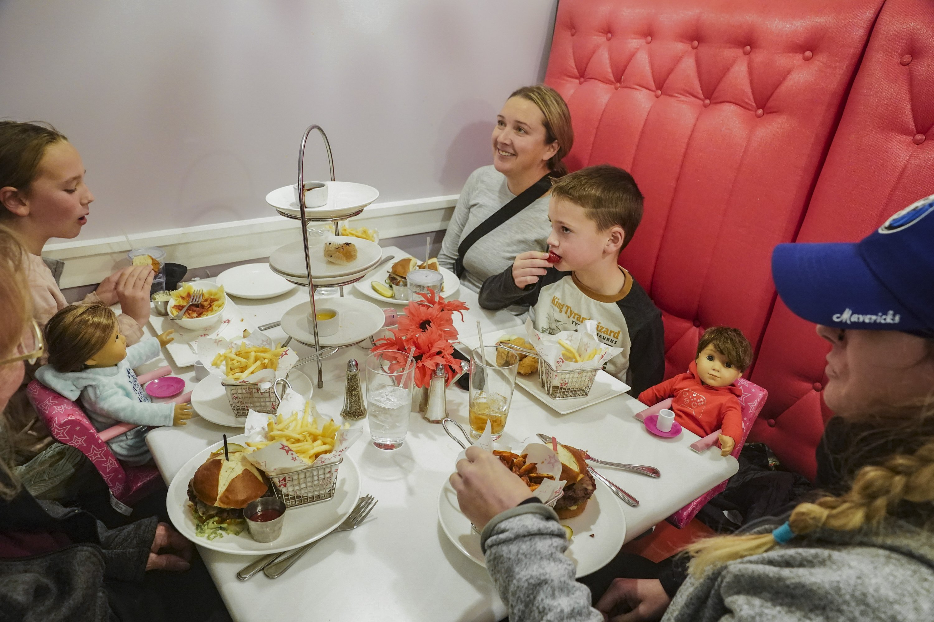 Elizabeth Hulanick (kanan) duduk bersama saudara perempuannya Sara Gaskill (CL) dan anak-anaknya untuk makan di American Girl Cafe, di New York, AS, 2 Desember 2022. (Foto AP)