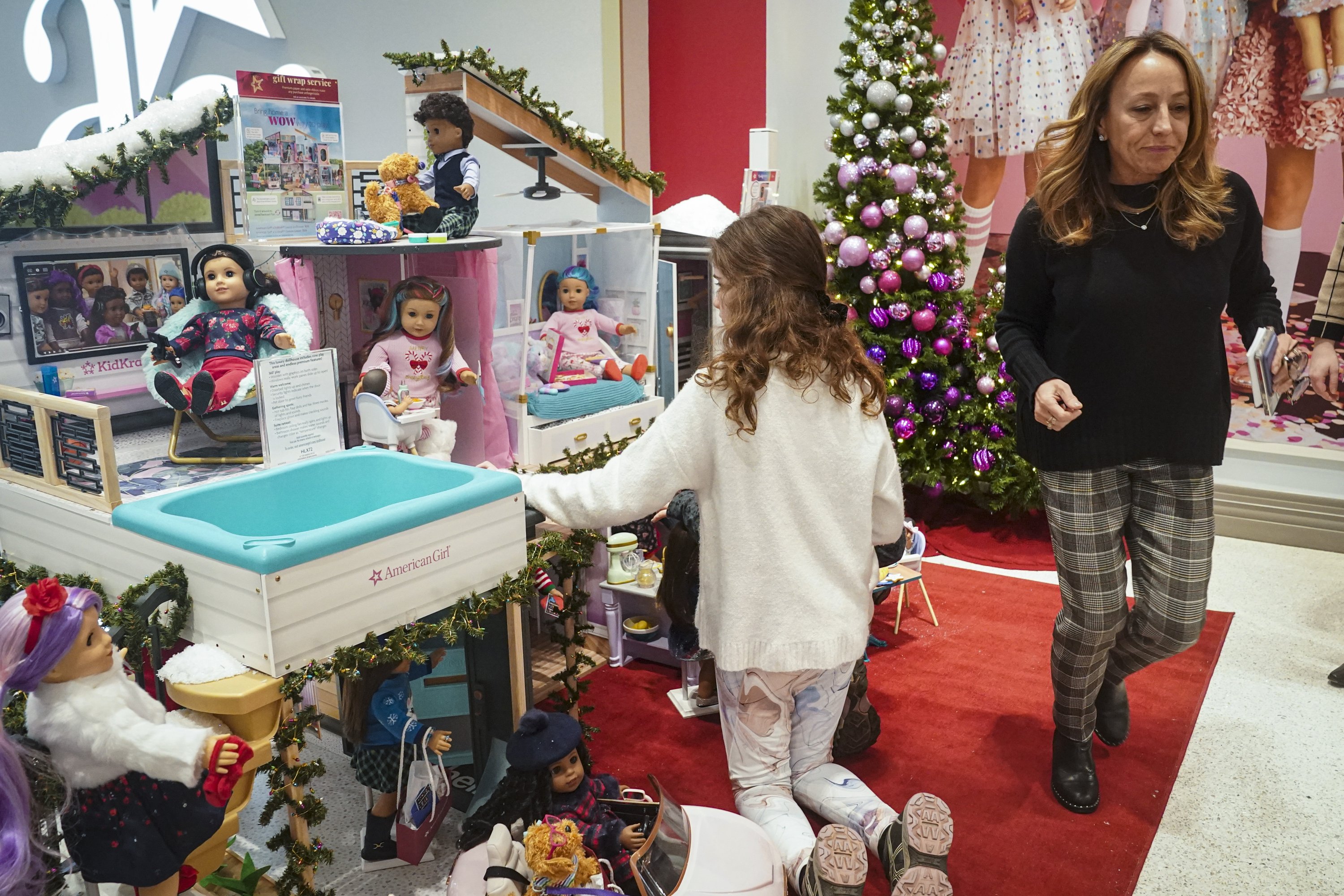 Jamie Cygielman (kanan), manajer umum dan presiden di American Girl, meninggalkan seorang anak muda melihat-lihat set boneka liburan terbaru perusahaan, di New York, AS, 2 Desember 2022. (Foto AP)