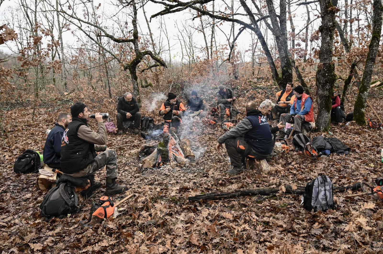 A group of lumberjacks take a rest around a woodfire in a forest near Grevena, northen Greece, Dec. 8, 2022. (AFP Photo)
