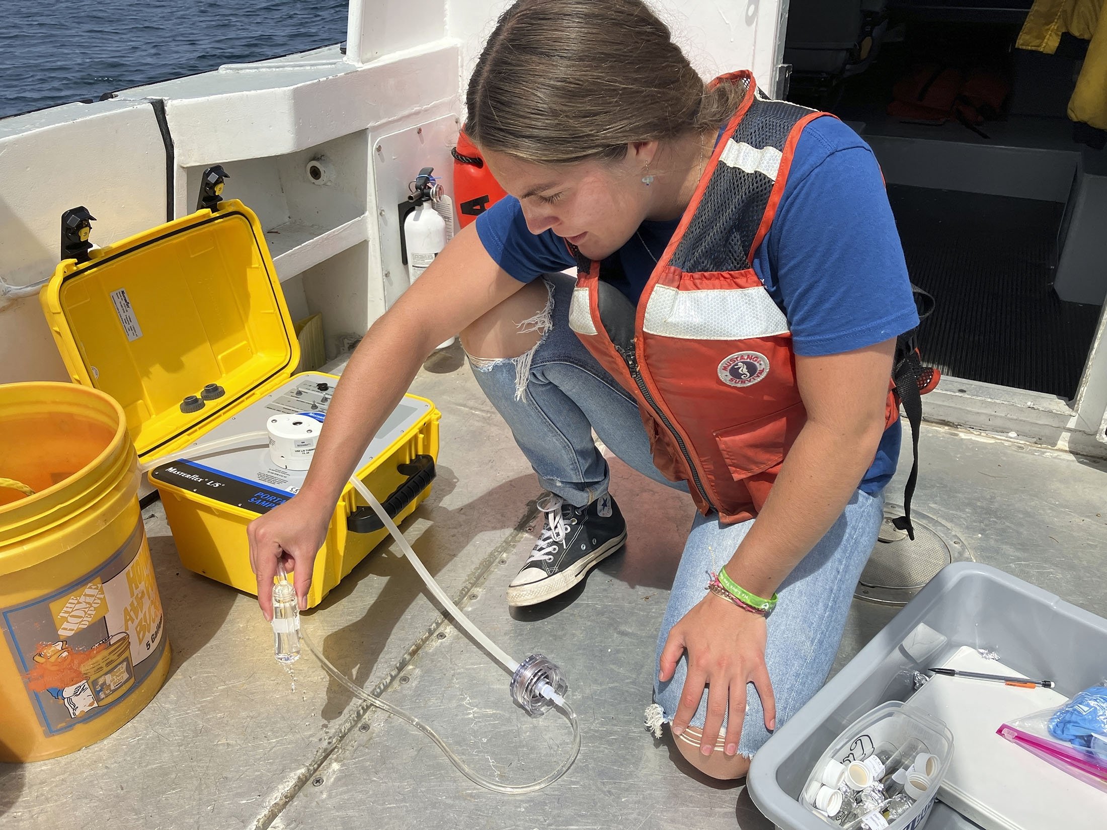 Michigan Sea Grant intern Cassidy Beach collects Lake Huron water samples aboard a research vessel, near Alpena, Michigan, U.S., July 13, 2022. (AP Photo)