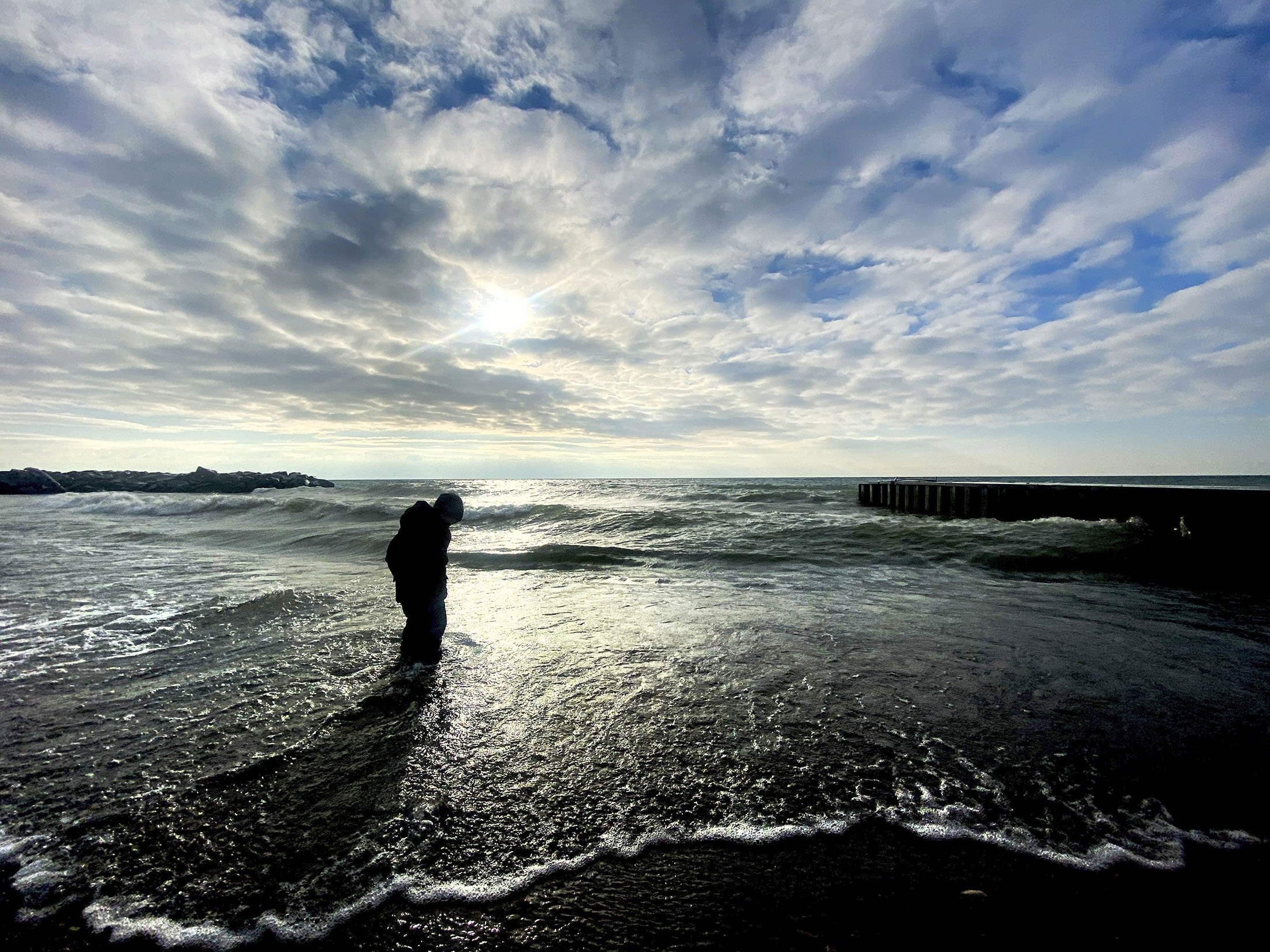 A young boy plays in the surf by the shore of Lake Ontario in Toronto, Canada, Jan. 21, 2021. (AP Photo)