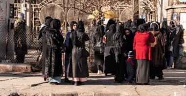 Afghan female university students stop by Taliban security personnel stand next to a university, Kabul, Afghanistan, Dec. 21, 2022. (AFP Photo)